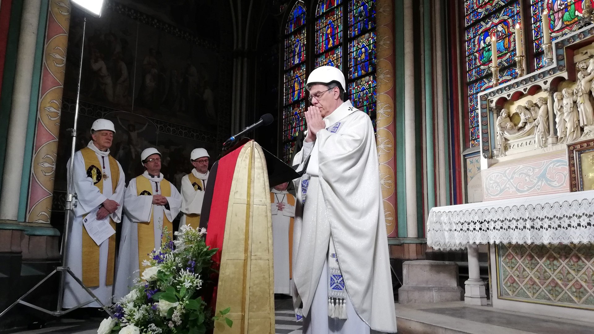 Priests in hard hats celebrate the first mass at Notre Dame since the devastating fire