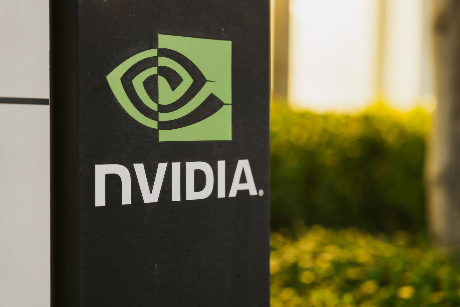 Close up on Nvidia's logo on a black pillar as the sun rises in the background, creating a hazy effect