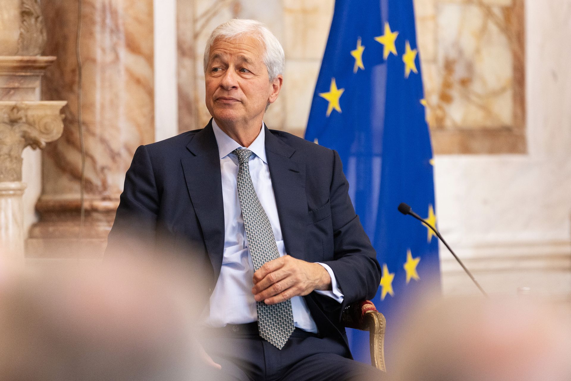 Jamie Dimon sits in front of an EU flag