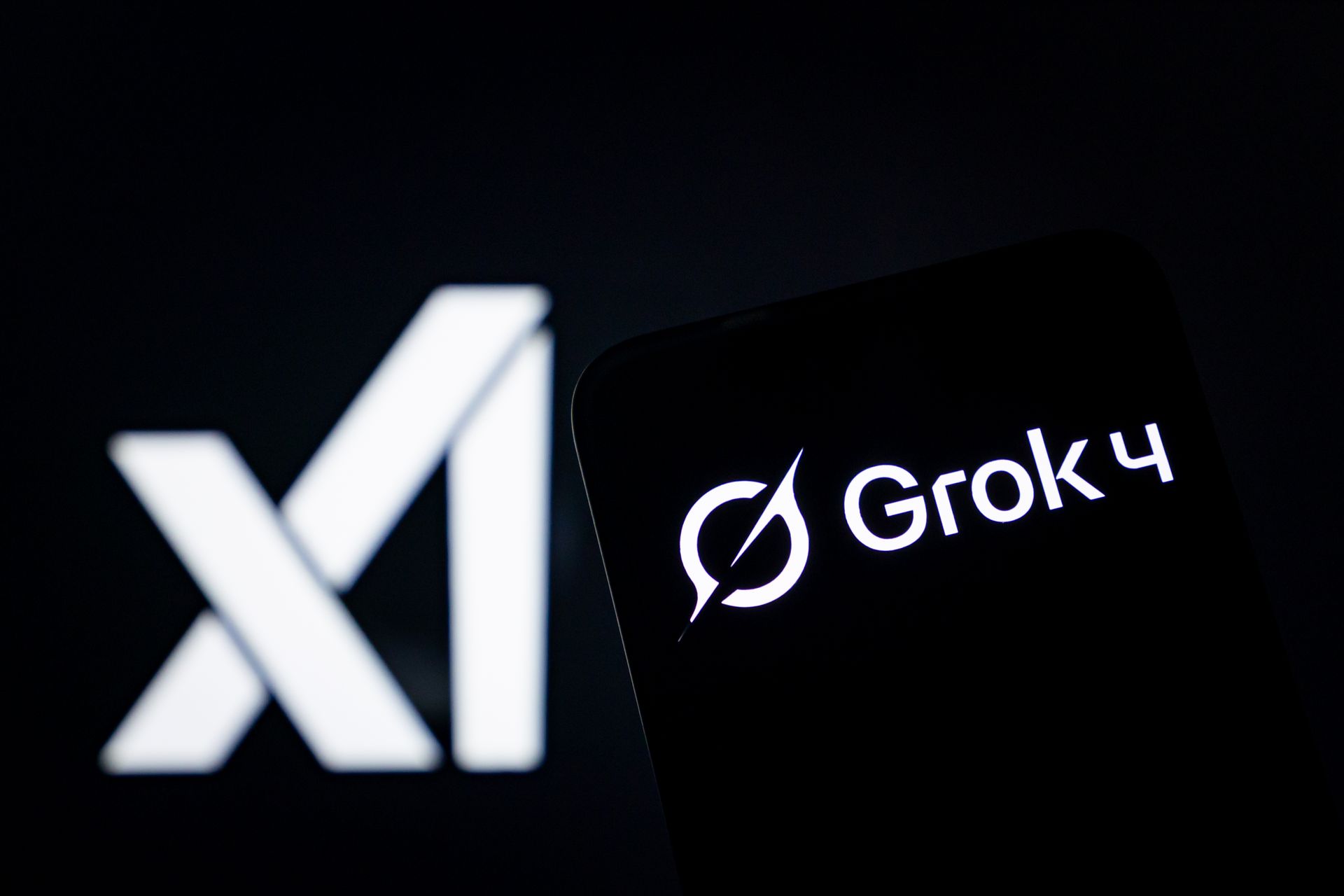 a black screen showing a "Grok 4" banner in white text in front of a larger banner (also black with white text) that has xAI's logo