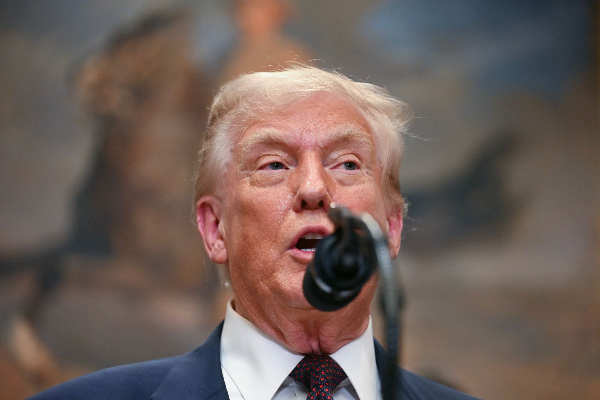 close-up photo of Donald Trump speaking into a microphone