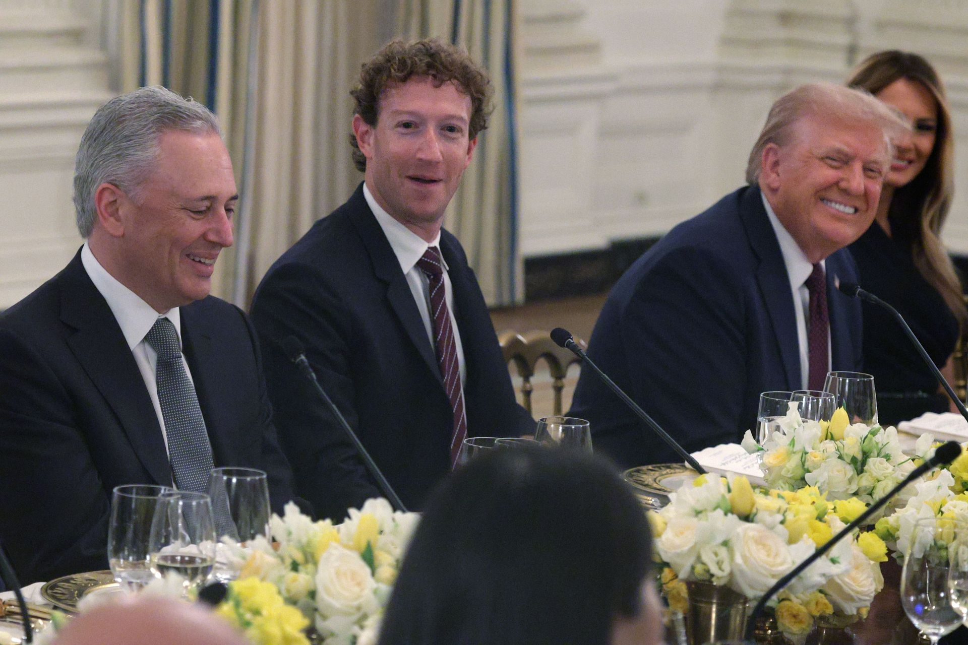 David Sachs, Mark Zuckerberg, President Donald Trump, and Melania Trump sit along a table covered with flowers in the White House State Dining Room