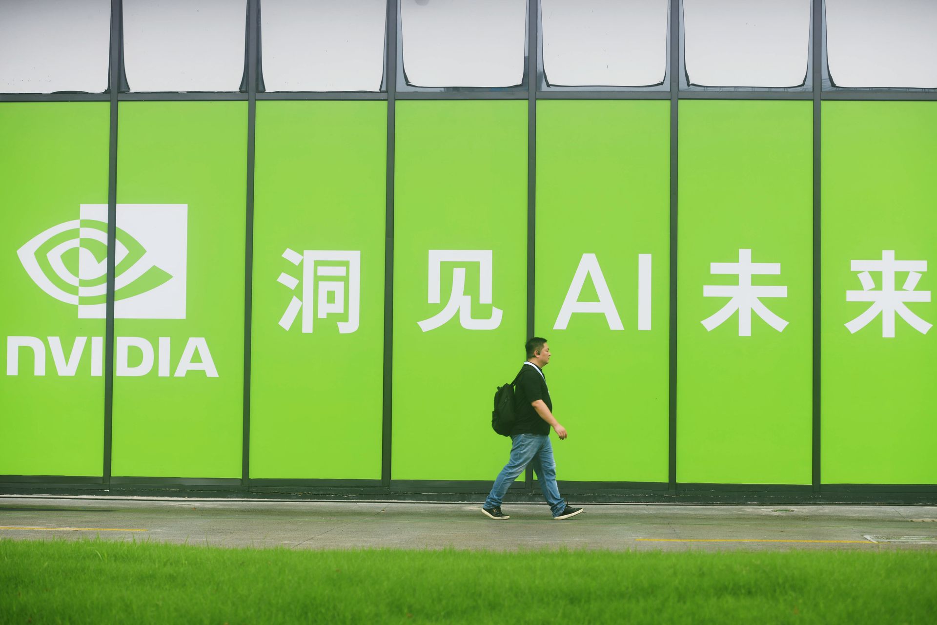 someone walks past the green NVIDIA booth with Chinese characters at the 2025 Apsara Conference in Hangzhou, Zhejiang Province, China